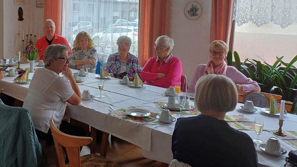 Mitglieder sitzen an Tisch.