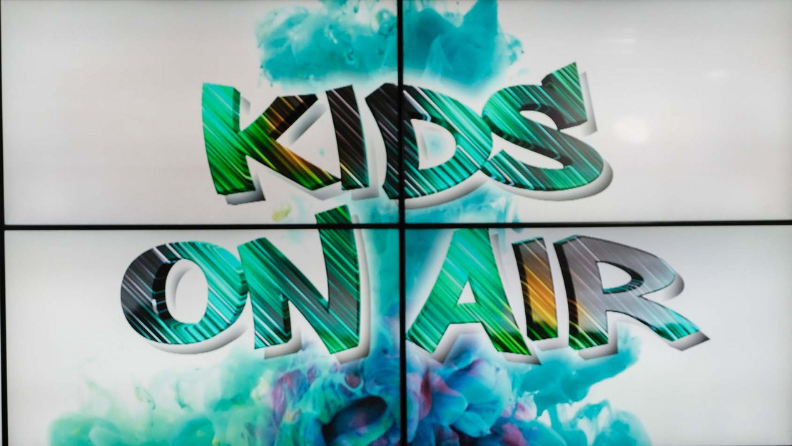 Schriftzug "Kids On Air" auf einer Bildschirmwand
