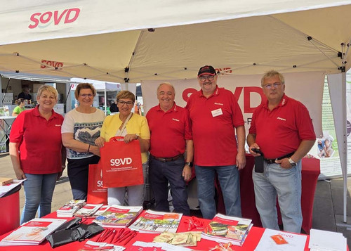 Sechs Personen an einem SoVD-Infostand. 