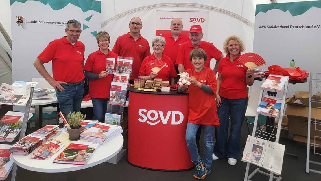 Gruppenfoto mit acht Personen an einem Infostand.