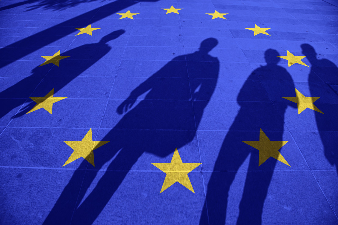 Menschliche Schatten auf einer EU-Flagge. 