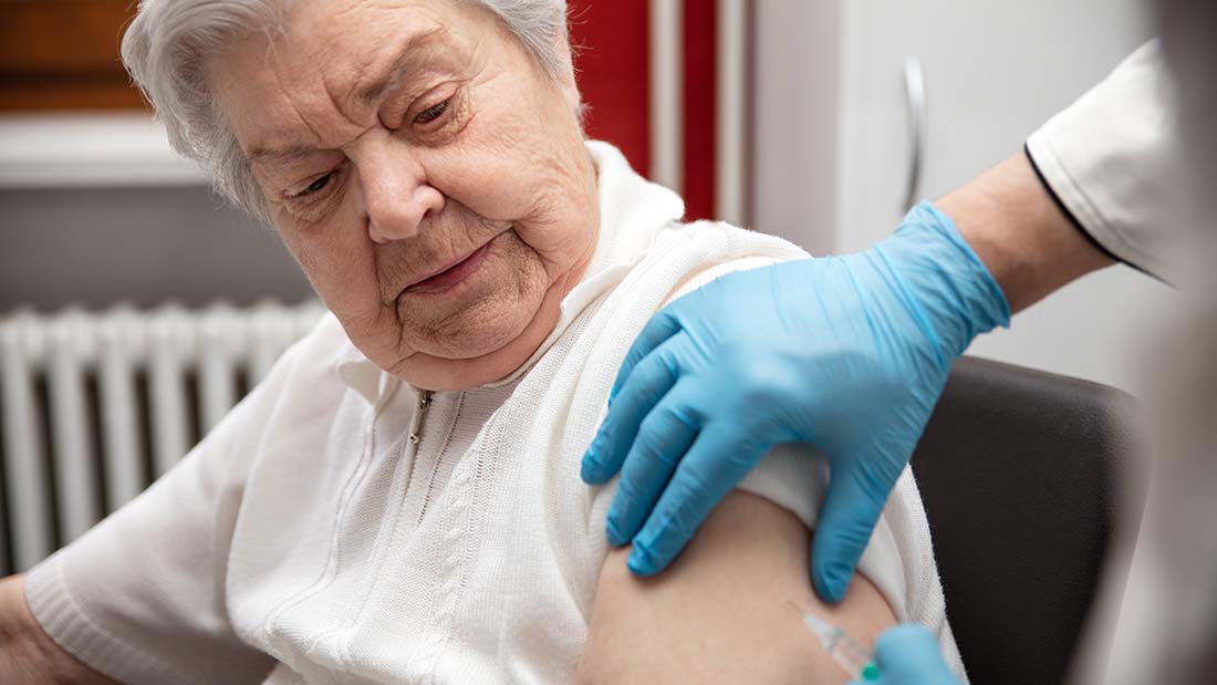 Ältere Frau erhält eine Impfung. 