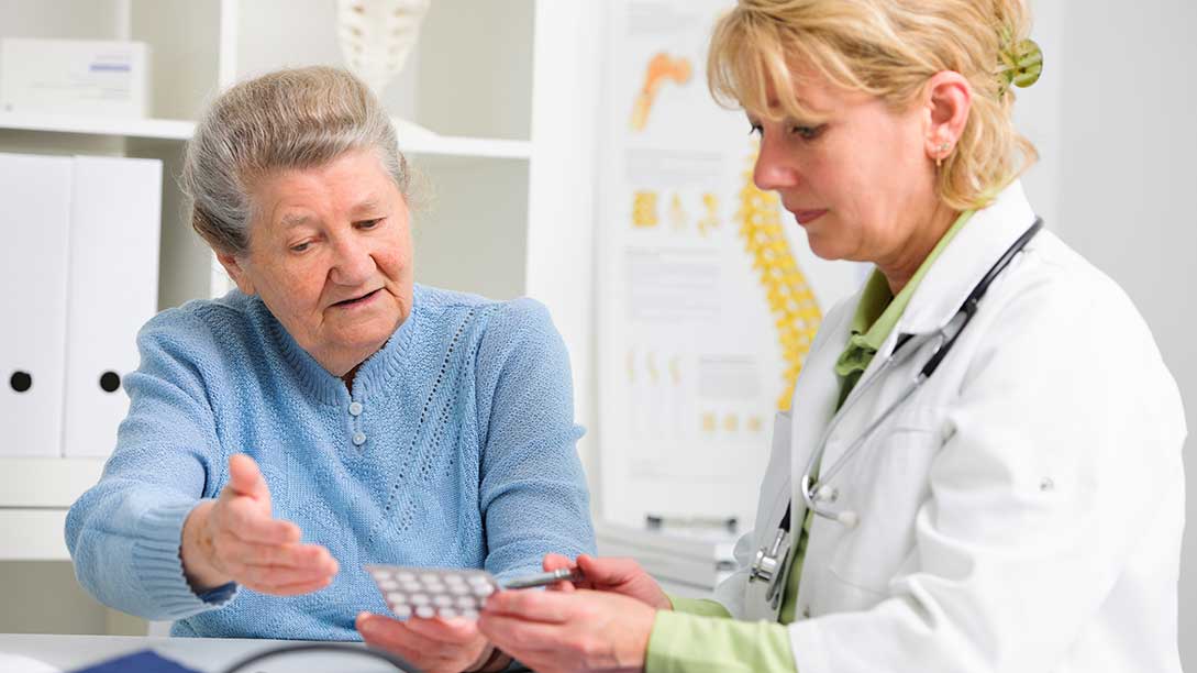 Ältere Patientin redet mit einer Ärztin in der Praxis. 