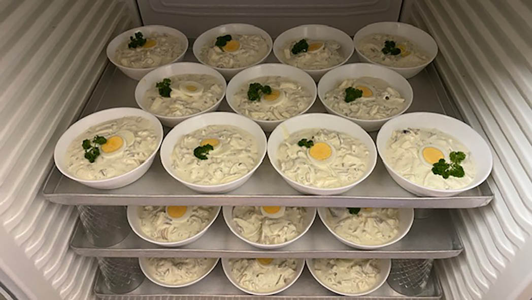 Kühlschrank voller Schüsseln mit Heringssalat.